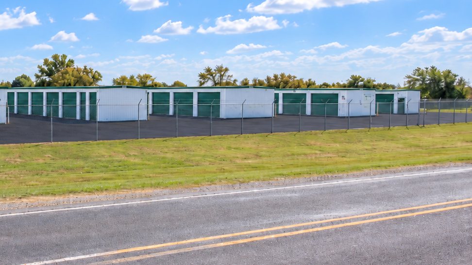 Storage buildings and paved lot seen from the road